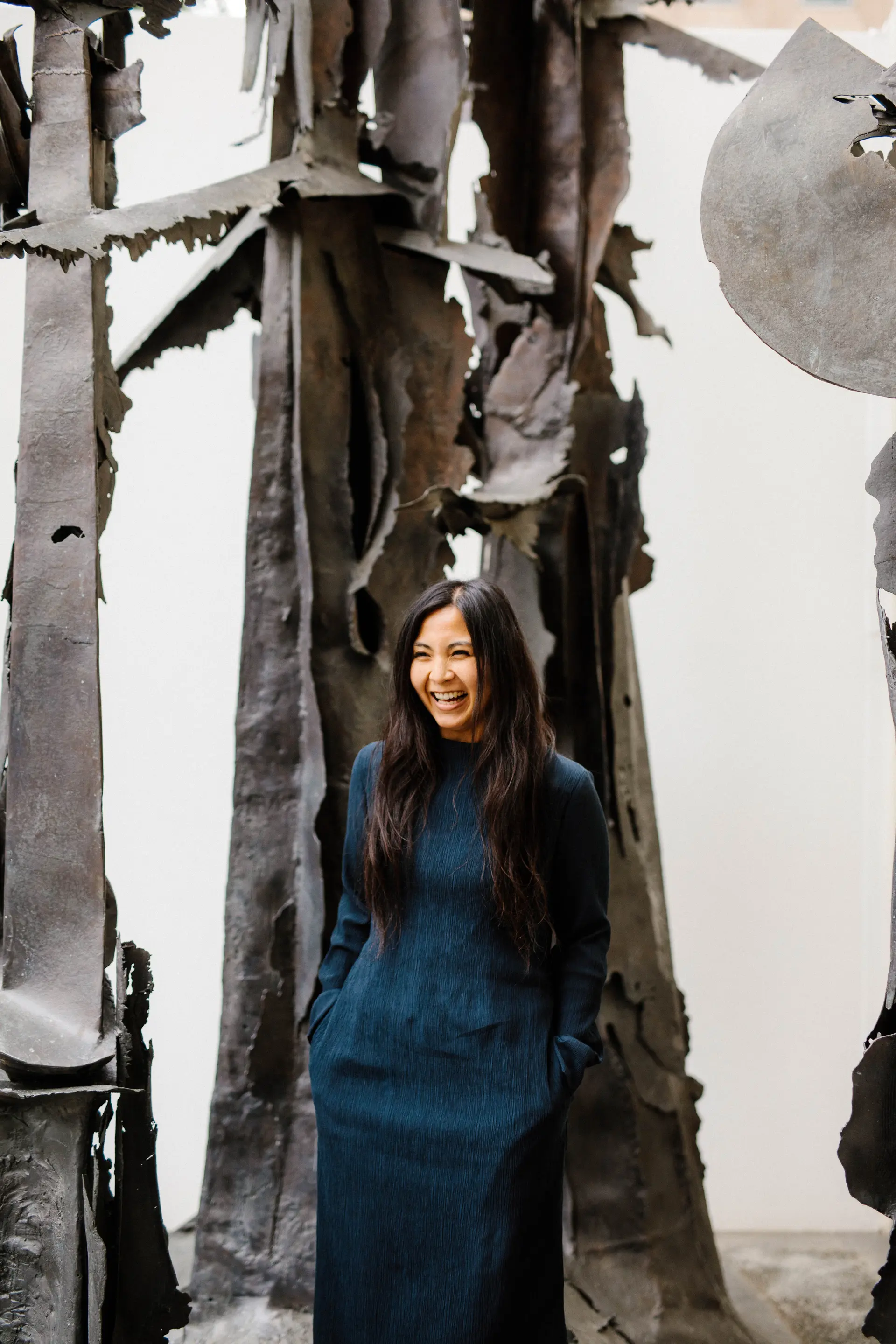 An image of Roz Bermudez standing in a dark blue dress laughing.