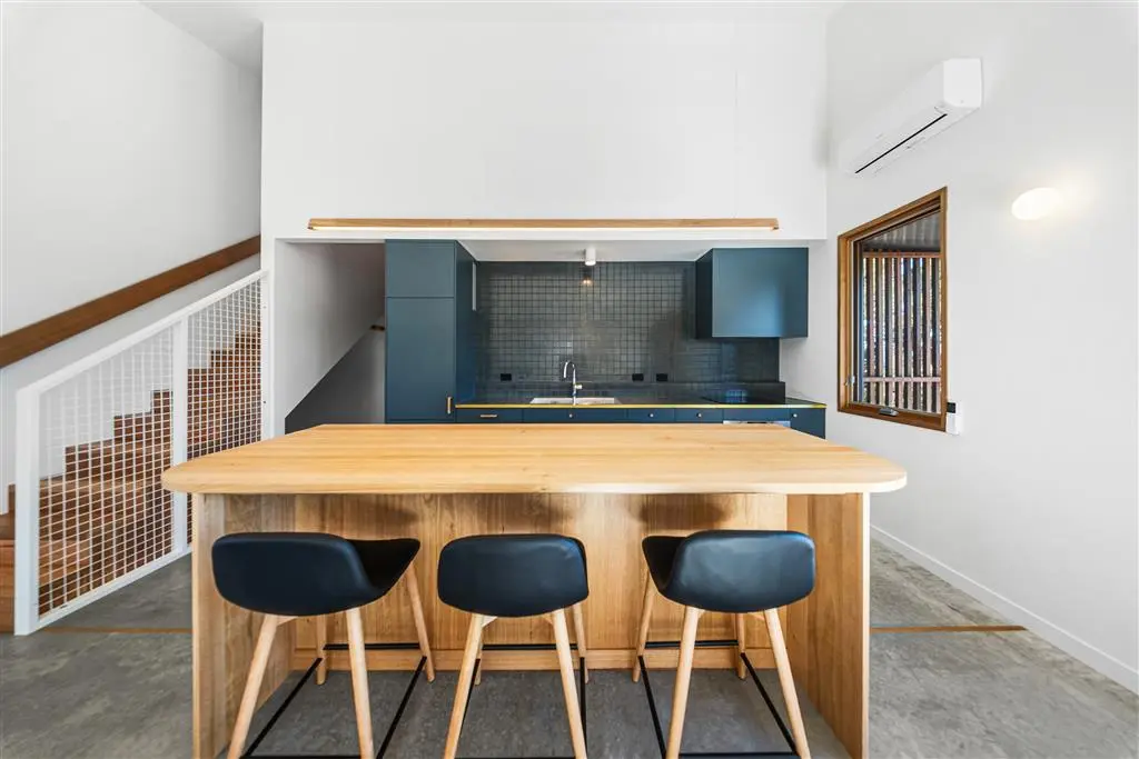 a kitchen with a timber island benchtop and white walls