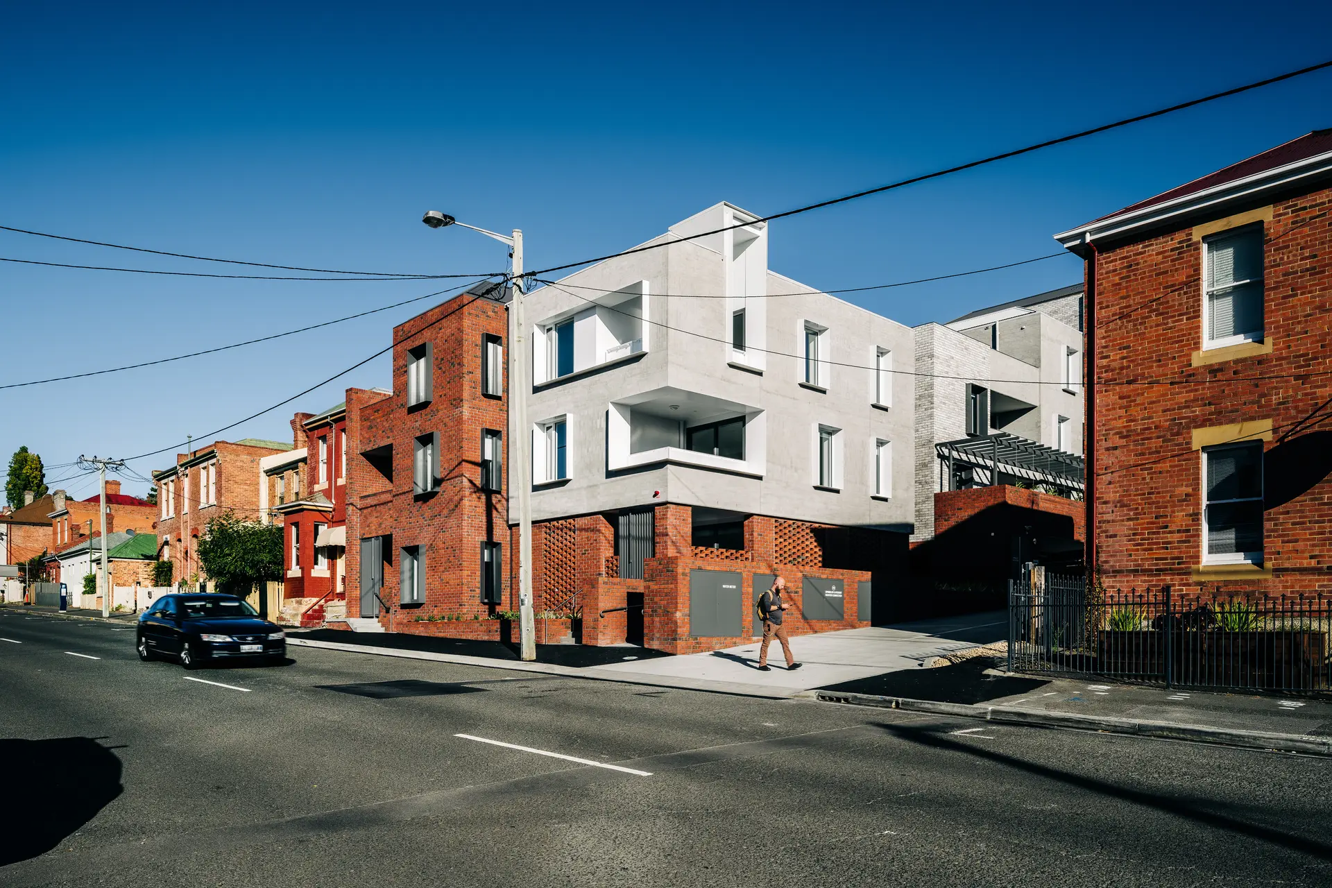 A street view of a unit complex, with a person in front of it.