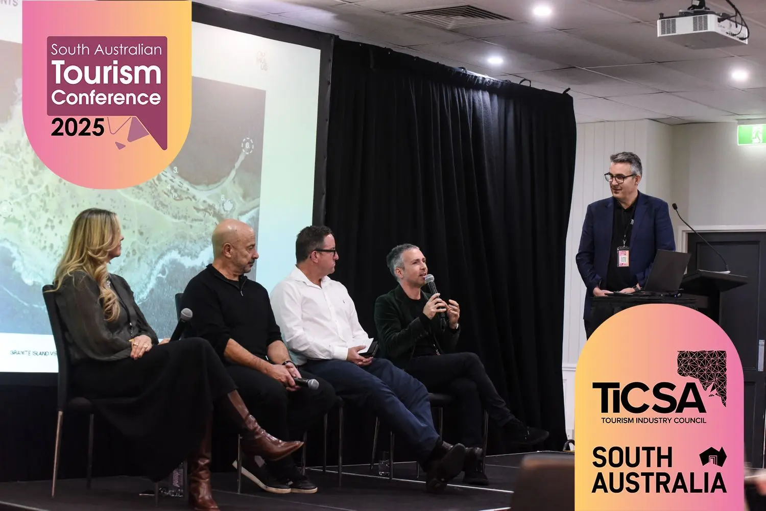 Another angle ofJet speaking at the South Australian Tourism Conference seated alongside 3 other attendents.