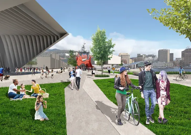Ground-level view of a proposed public park at Castray Point with people walking, cycling, and relaxing on grassed areas, framed by geometric architecture and a central, sculptural red pavilion, with Hobart’s city framed in the background.