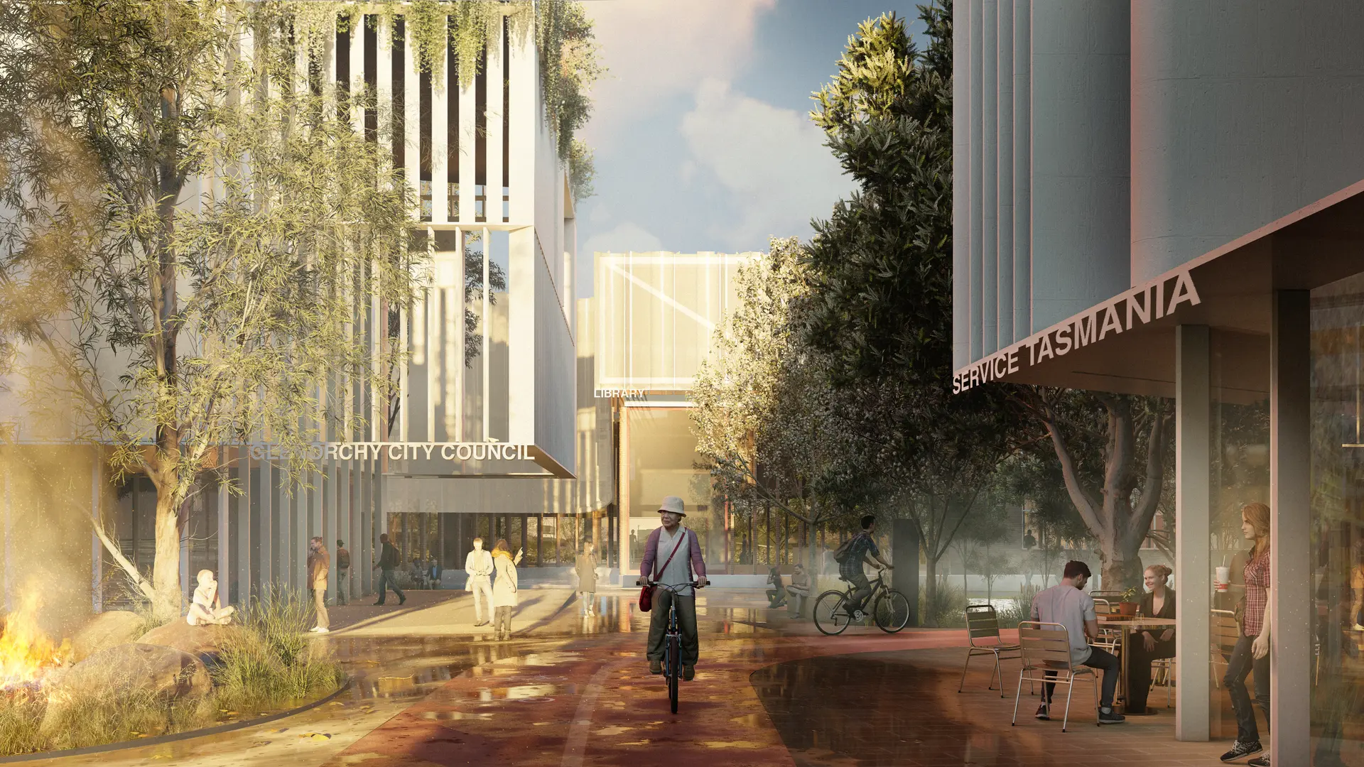 A render of an external alleyway between Council and Service Tasmania buildings clad with a similar vertical white fin facade sees the public utilising the shared spaces, riding bikes on the earthen red ground, eating on outdoor seating spilling out of a nearby ground-level cafe, and enjoying established native gardens and covered decks. Large melaluca trees fill the courtyard, with atmospheric wet play zones beneath.