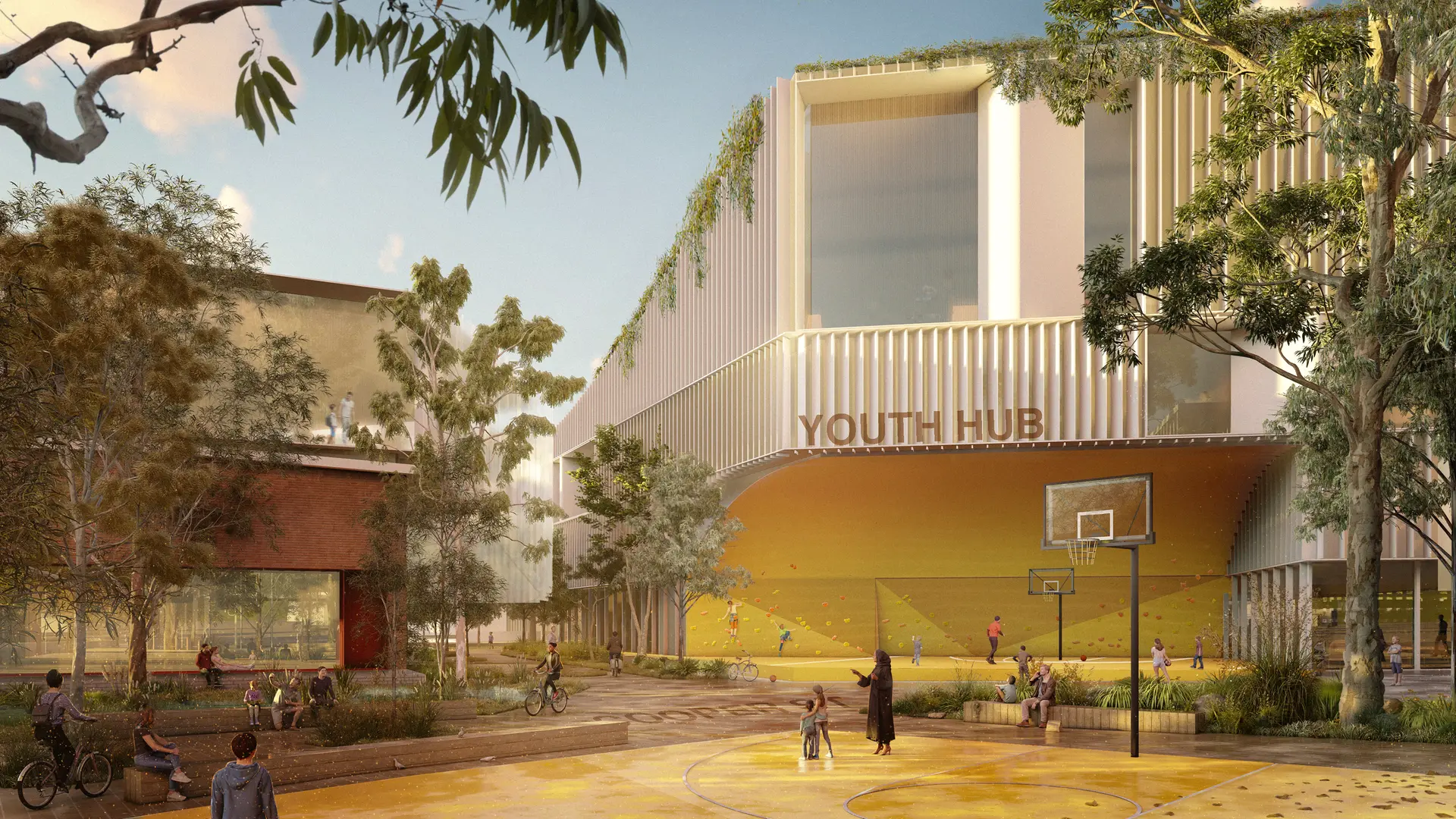 Renders of a youth hub building are framed by native vegetation and muture gum trees, the bold yellow of the basketball court in the front of the image also extends to the underside of the building cantilever behind, creating a designated, sheltered rock climbing space. Large windows overlook the play plaza, both in the new, white, vertical fin panelled building to the right, and set into the existing red brick building on the left, which provides glimpses into the library spaces.