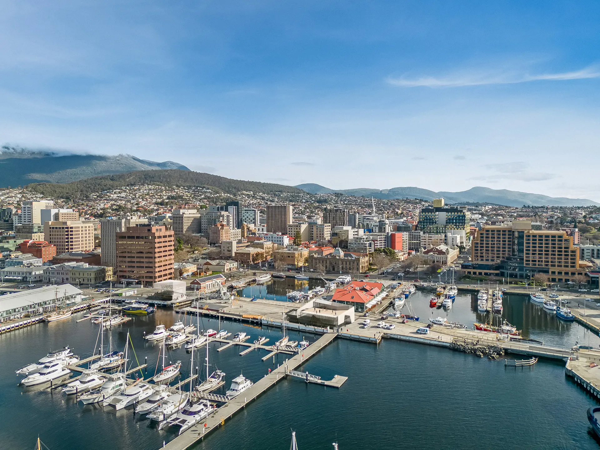 Composite image illustrating two proposed dockhead buildings, merged into an aerial view of the Sullivans Cove area with Hobart in the background.