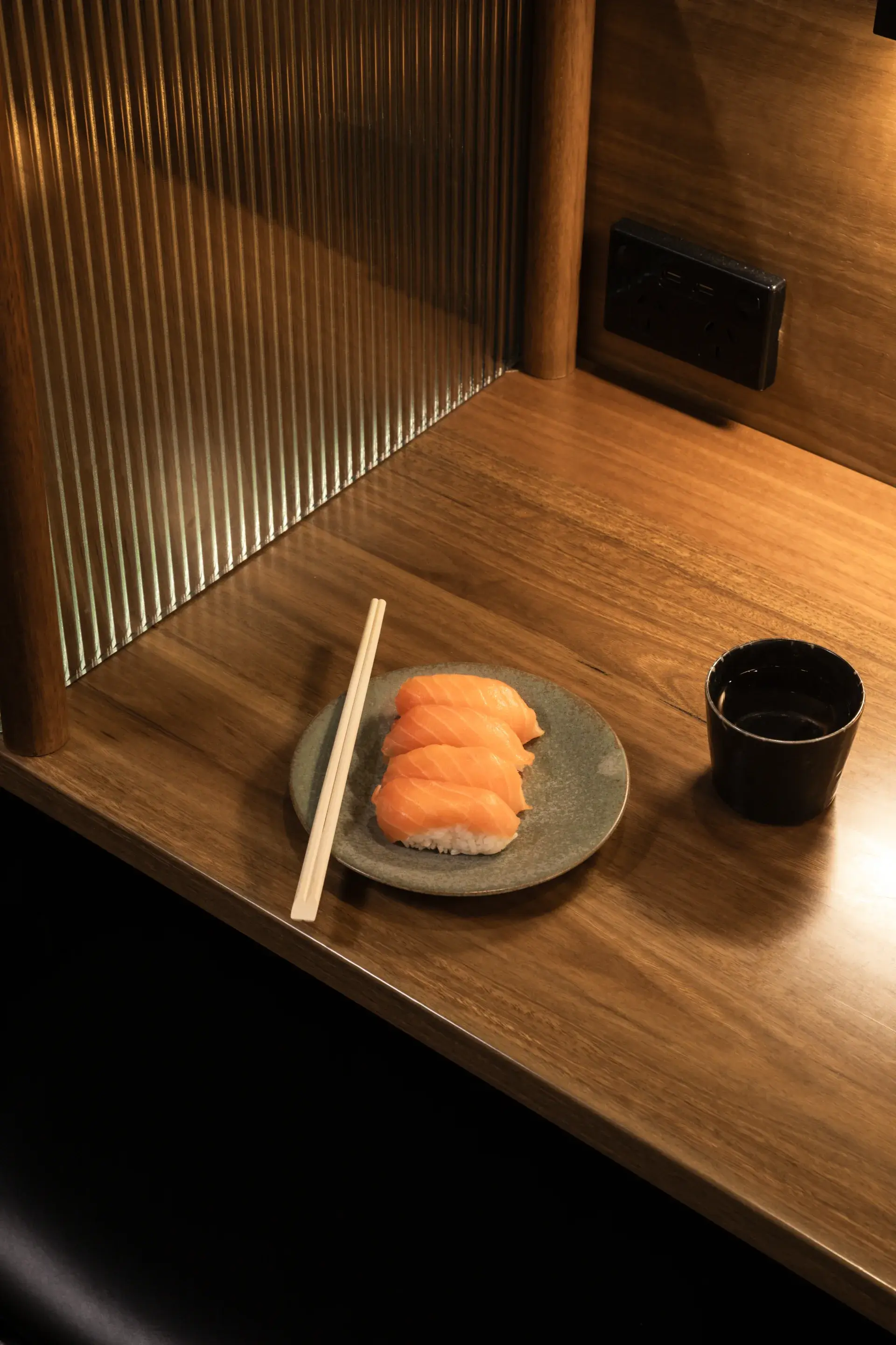 Intimate private dining space with fluted glass screens along a floating timber table, creating privacy and elegance for lunch or dinner at Midori.
