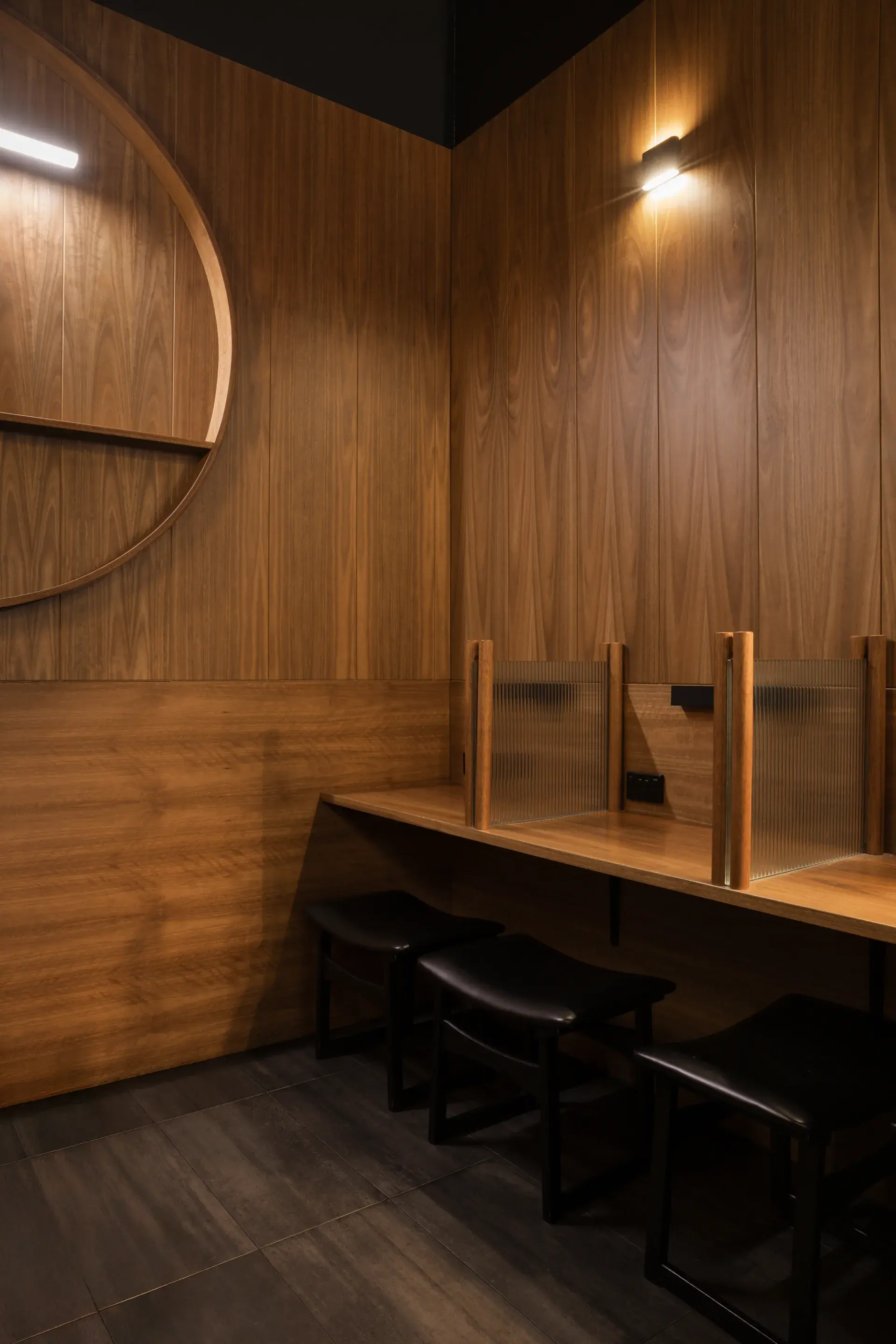 Spotted gum wall panelling in vertical and horizontal arrangements references traditional Japanese interiors, with a circular shelf for ceramics.