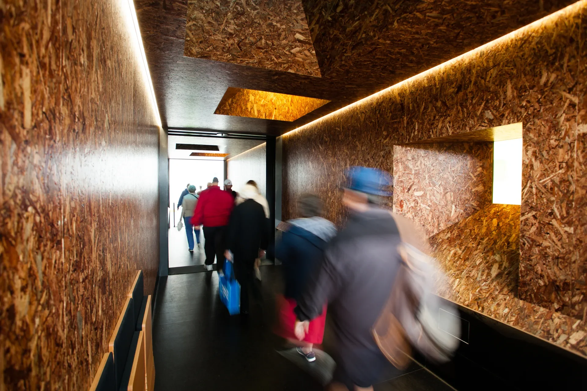 Blurred images of cruise ship visitors as they move through the timber lined interior of one of the shelters.