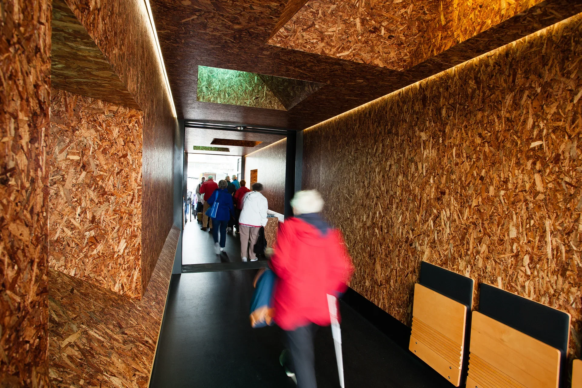 An image of the timber lined interior with ship-like angled portholes that let natural light into the space.