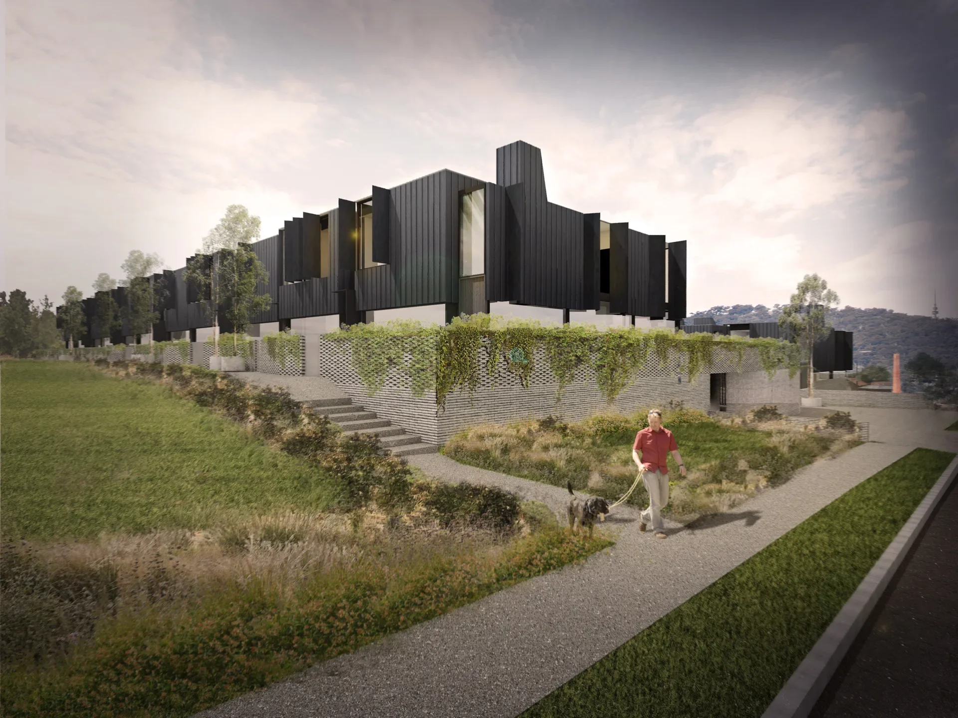 A row of metal-clad townhouse volumes steps along a landscaped edge, sitting above a textured brick podium that conceals basement parking. Vertical fins and chimney-like skylights articulate each dwelling, with Canberra’s Telstra Tower visible in the distance and the historic Brickworks chimney rising in the foreground.