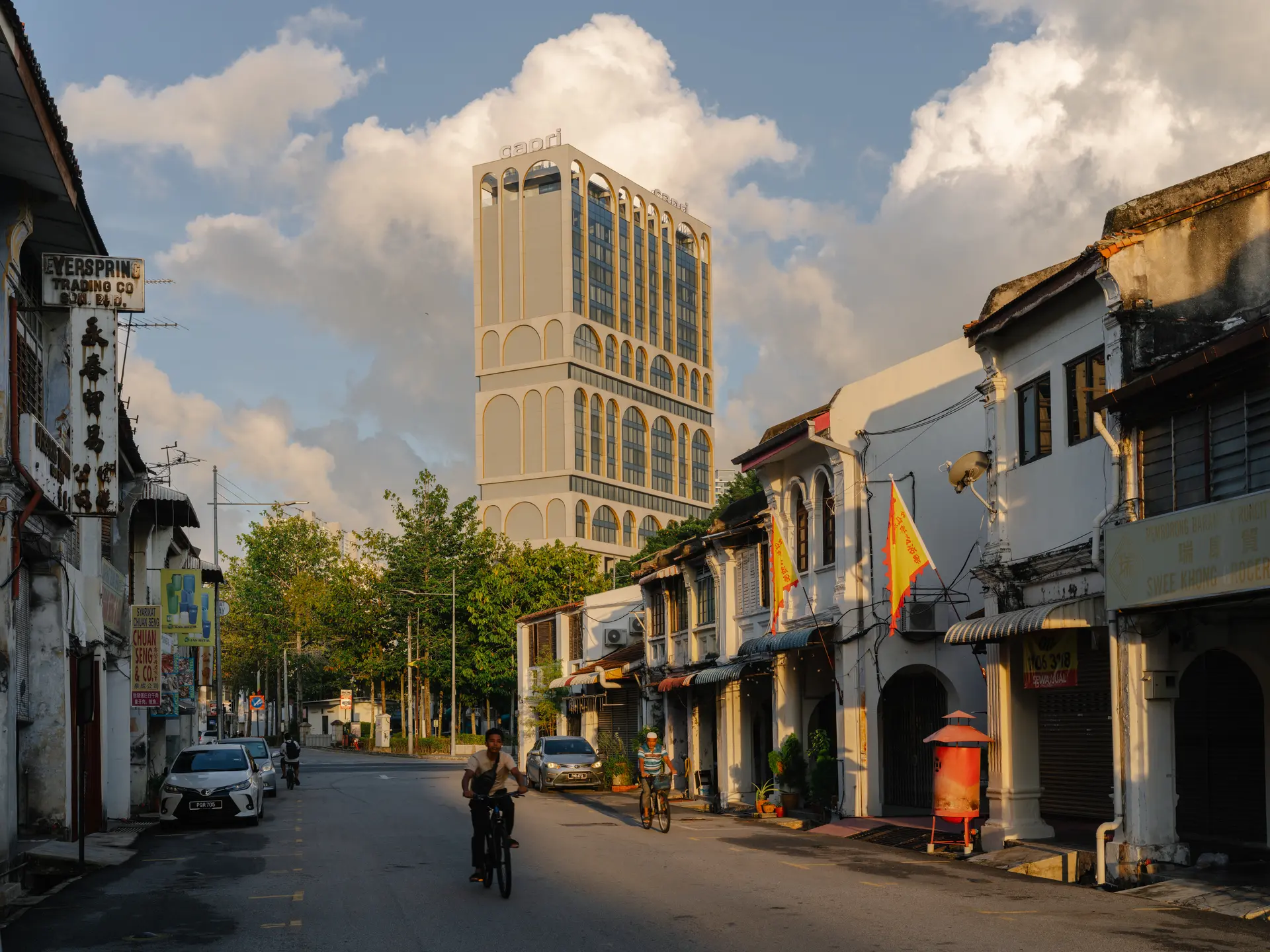 An arched facade of a hotel sitting within the surrounding context of George Town, Penang.